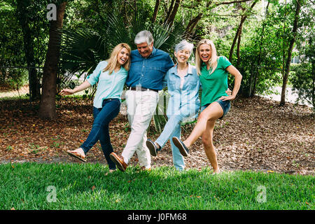 Coppia senior e due figlie adulte in parco divertimento Foto Stock