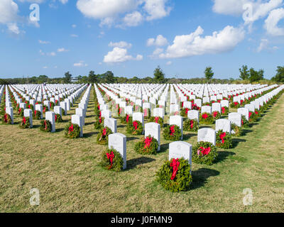 Righe della tomba di pietra con ghirlande & rosso archi a Sarasota Cimitero Nazionale in Sarasota Florida Foto Stock