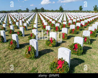 Righe della tomba di pietra con ghirlande & rosso archi a Sarasota Cimitero Nazionale in Sarasota Florida Foto Stock