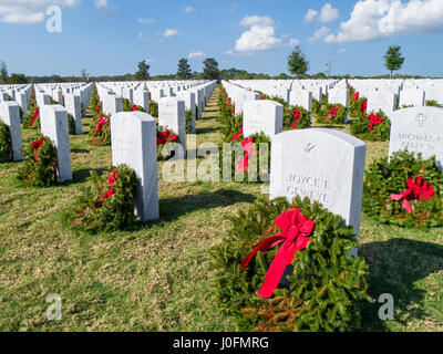 Righe della tomba di pietra con ghirlande & rosso archi a Sarasota Cimitero Nazionale in Sarasota Florida Foto Stock