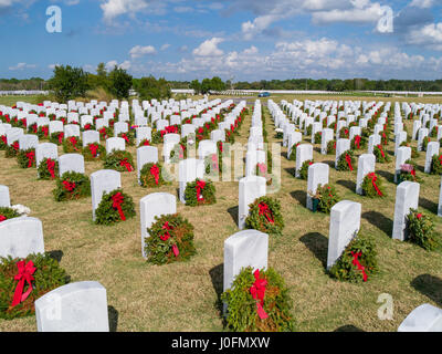 Righe della tomba di pietra con ghirlande & rosso archi a Sarasota Cimitero Nazionale in Sarasota Florida Foto Stock