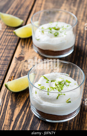 Calce cruda cheesecake in un vetro su legno tavolo rustico Foto Stock