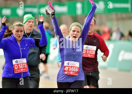 Molto felice runner attraversando il traguardo al 2017 Shamrock Shuffle gara a Chicago, Illinois, Stati Uniti d'America. Foto Stock