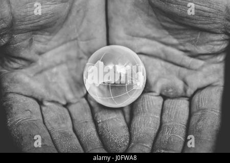 Il vetro del pianeta terra in mano Foto Stock