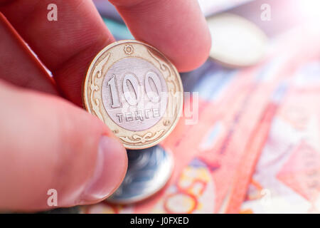 Un centinaio di tenge in mano. Contro lo sfondo del Kazakistan in denaro. Foto Stock
