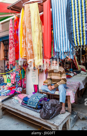 Maschio barbuto negoziante Sikh in un colorato negozio di tessuti indossando tipici turbante, Pragpur, un villaggio del patrimonio culturale nel quartiere Kagra, Himachal Pradesh, India Foto Stock