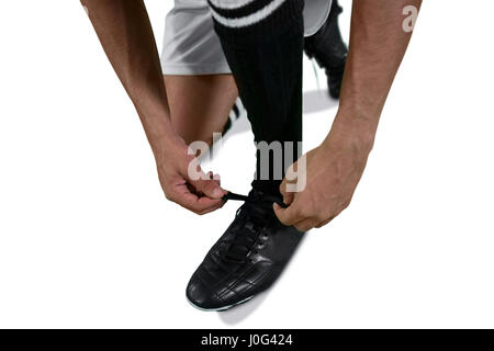 Giocatore di football la sua legatura laccio su sfondo bianco Foto Stock