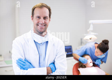 Ritratto di dentista in piedi con le braccia incrociate in clinica Foto Stock