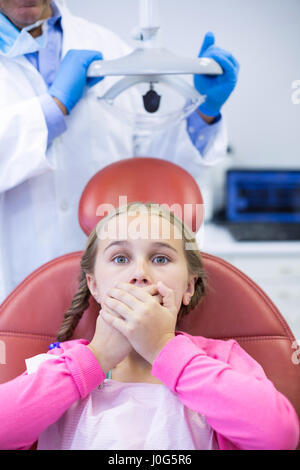 Paziente giovane spaventata durante un dentista di check-up presso la clinica Foto Stock