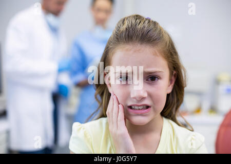 Ritratto di giovane infelice paziente avente un mal di denti in clinica dentale Foto Stock