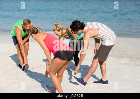 Maschio e femmina di amici che esercitano in riva al mare Foto Stock