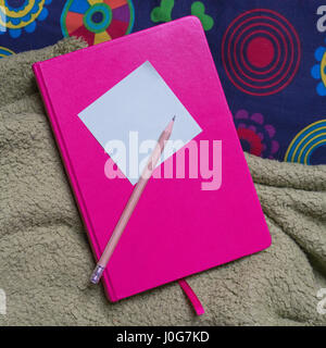 Notebook rosa, penna e nota adesiva Foto Stock