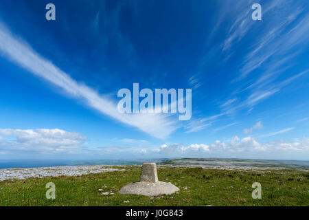 Cirrus cloud oltre il punto di innesco al vertice principale di montagna Gleninagh, Burren, County Clare, Irlanda Foto Stock