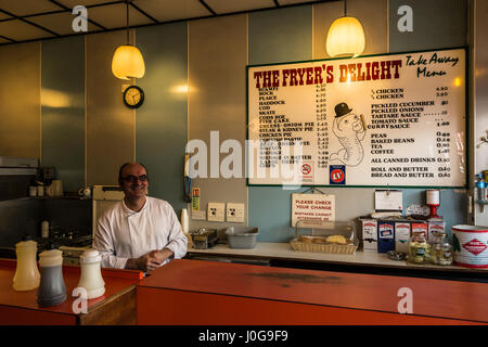 Bei pesci e schegge che lavorano dietro il bancone al Fryer's Delight Fish and chip Shop su Theobalds Road, Bloomsbury, Londra, Inghilterra, Regno Unito Foto Stock