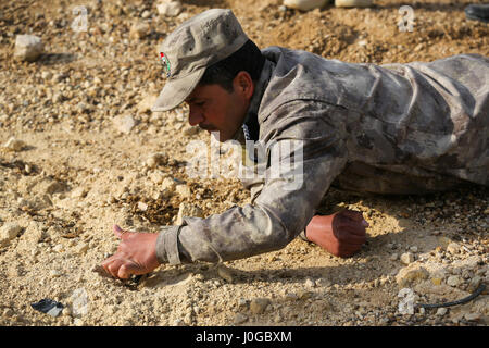 Una delle forze di sicurezza irachene soldato rimuove i detriti per cercare un hidden finti esplosivi improvvisati dispositivo durante il contro-IED formazione presso Al Asad Air Base, Iraq, Marzo 29, 2017. Questa formazione fa parte del complesso di Combined Joint Task Force - Funzionamento inerenti risolvere la costruzione di capacità del partner la missione di formazione e migliorare la capacità di partnership forze che lottano ISIS. CJTF- funzione OIR è la coalizione globale per sconfiggere ISIS in Iraq e la Siria. (U.S. Esercito foto di Sgt. Lisa soia) Foto Stock