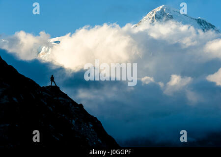 Un trekker guardando Cho Oyu (8188 m) in Nepal Himalaya. Foto Stock