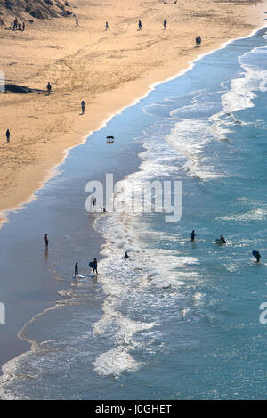 Mare Crantock Beach sabbia di mare vacanzieri sagome stagliano persone figure Shore litorale sera Turismo Foto Stock