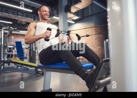 Atleta maschio lavorando sulla macchina a remi Foto Stock