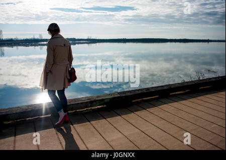 Figura femminile accanto all acqua con suns riflessione Foto Stock