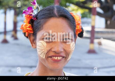 Myanmar donna con thanaka sul suo Smiley face Mandalay, Myanmar. Thanaka è un colore bianco giallastro cosmetic pasta costituita da corteccia di massa. Foto Stock