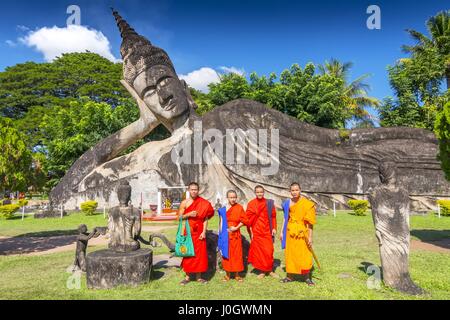 I monaci con il Buddha reclinato a Xieng Khuan Buddha Park Vientiane Laos. Foto Stock