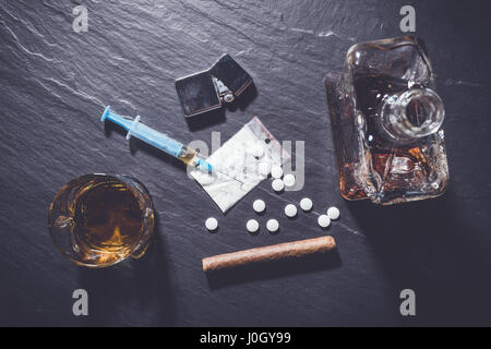Droghe e alcol in pietra scura sullo sfondo Foto Stock
