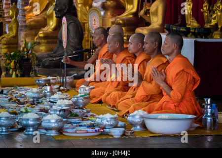 I monaci buddisti pregano per benedire il cibo dato elemosine durante il Songkran 2017 celebrazioni nelle zone rurali a Nakhon Nayok, Thailandia Foto Stock