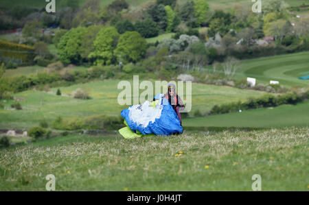 Brighton, Regno Unito. Xiii Apr, 2017. Circa 50 i parapendii scese sulla Devils Dyke appena a nord di Brighton questa mattina con le perfette condizioni di volo di un nord ponentino e calda dei sistemi di raffreddamento sulla South Downs nel Sussex . Il tempo dovrebbe essere lo scambiatore di calore in tutta la Gran Bretagna per la Pasqua banca credito vacanze: Simon Dack/Alamy Live News Foto Stock