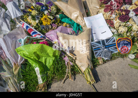 Omaggi floreali, collocati al di fuori del Palazzo di Westminster, alle vittime della Westminster attacco di Khalid Massud che scorreva giù i pedoni sulla West Foto Stock