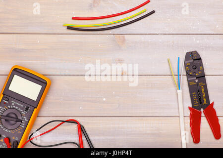 L'elettricista's tools giacciono su un sfondo di legno. Vi è spazio per il testo nel centro Foto Stock