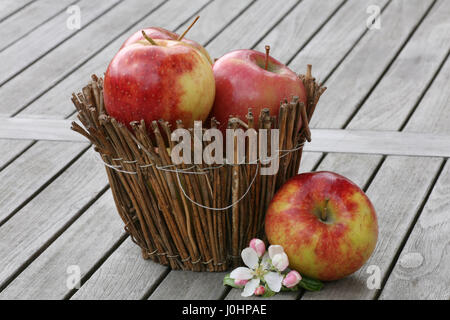 Le mele rosse nel cesto tessuto Foto Stock