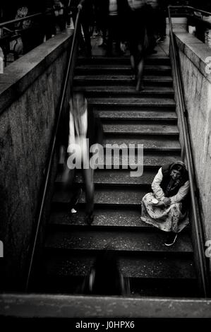 Ritratto di un mendicante all' ingresso della metropolitana milanese, preso in Piazza Duomo fermata. Foto Stock