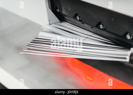 Close up di un taglio della carta macchina a ghigliottina con i ritagli di carta Foto Stock