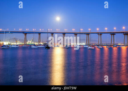 La luna sorge sopra il ponte di Coronado e del Porto di San Diego di notte. Coronado, California, Stati Uniti d'America. Foto Stock
