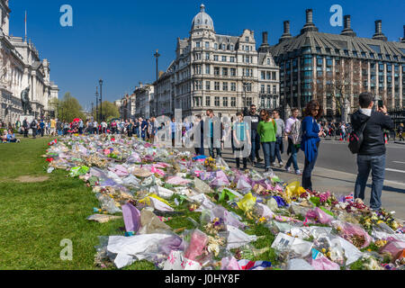 Omaggi floreali, collocati al di fuori del Palazzo di Westminster, alle vittime della Westminster attacco di Khalid Massud che scorreva giù i pedoni sulla West Foto Stock