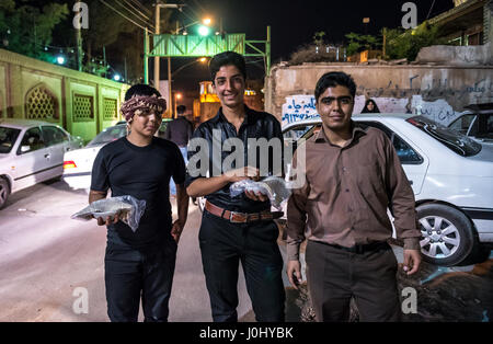 I giovani iraniani pongono con carità nazri cibo servito in durante Muharram santo mese, Kashan città, capitale della contea di Kashan dell'Iran Foto Stock