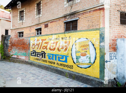 Pubblicità per un negozio di alimentari segno dipinta su un muro di mattoni in una strada Pragpur, un villaggio del patrimonio culturale nel quartiere Kagra, Himachal Pradesh, India Foto Stock