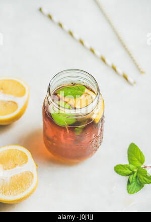 Estate freddo tè ghiacciato con le fette di limone e le erbe aromatiche fresche Foto Stock