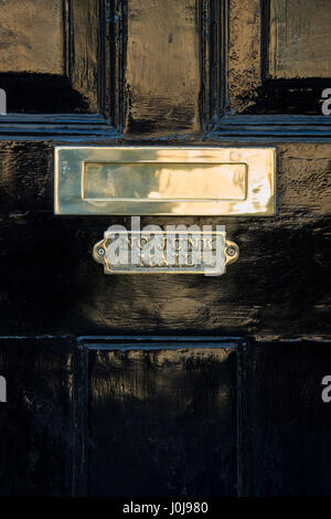 N. di posta indesiderata della placca in ottone sotto una buca delle lettere in ottone su un nero casa in legno porta. Cotswolds, Inghilterra Foto Stock