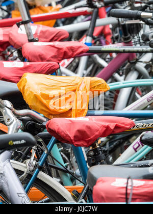 Studente Biciclette parcheggiate a Cambridge nel Regno Unito. Posti a sedere sono protetti dalla pioggia per mezzo di coperchi amovibili. Foto Stock