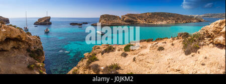 A Comino e Malta - La splendida laguna blu con il turchese chiaro l'acqua di mare, yachts e snorkeling turisti su una soleggiata giornata estiva con l'isola di Gozo Foto Stock