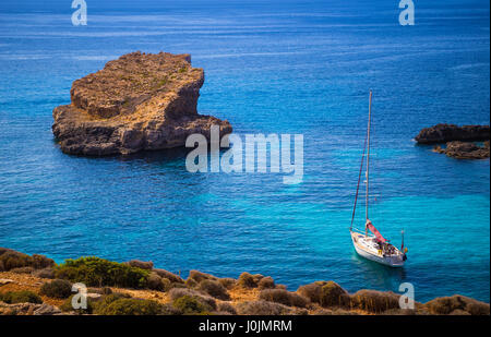 Blue Lagoon, Malta - barca a vela presso la famosa laguna blu presso l'isola di Comino su soleggiate giornate estive con crystal clear azure acqua di mare Foto Stock