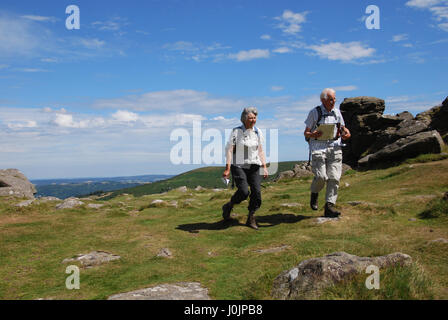 Coppia di anziani, camminando su Hound Tor, Dartmoor National Park Regno Unito Foto Stock