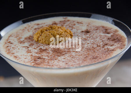 Il Rum scosso con Frangelico, Amaretto e doppia panna - guarnita con un biscotto amaretto e cioccolato fondente Foto Stock