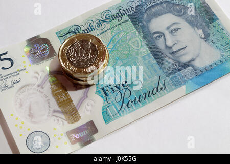 Nuova moneta inglese e nuova nota da cinque sterline, valuta di denaro Foto Stock
