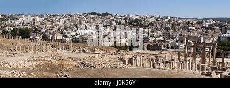 Le rovine della città di Gerasa, uno dei più grandi e ben conservati siti di architettura romana nel mondo e lo skyline di Jerash moderno Foto Stock