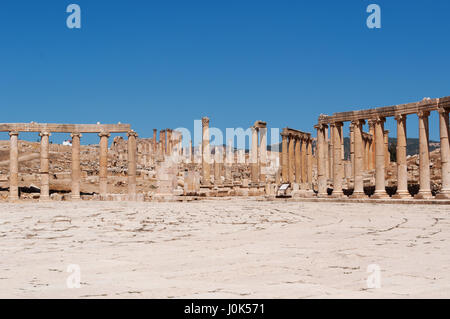 Jerash Oval Plaza, la piazza principale della città archeologica circondata da un ampio marciapiede e un colonnato del primo secolo di colonne ioniche Foto Stock