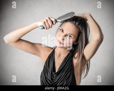 Brunette donna spazzolare i capelli Foto Stock