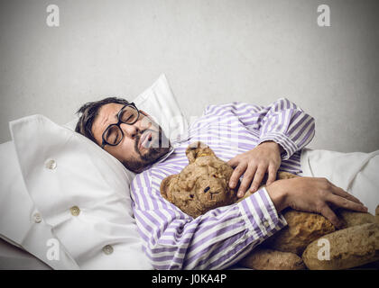Uomo dorme con il suo orsacchiotto di peluche Foto Stock