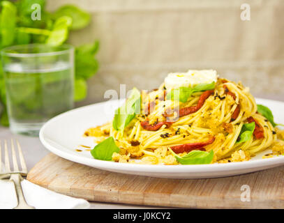 Spaghetti con pomodori secchi basilico mozzarella Foto Stock